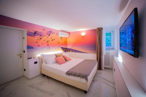 a bedroom with a bed with a painting on the wall at Marina Centro Suite in Rimini
