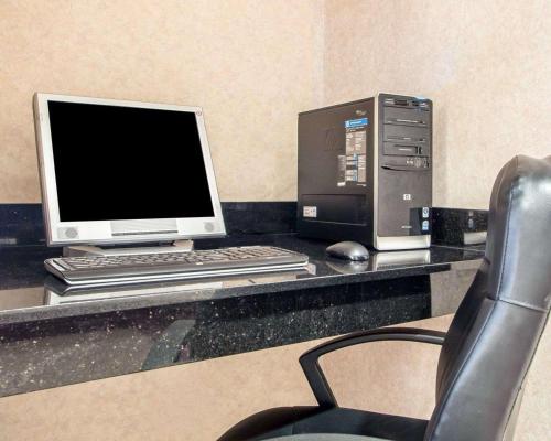 a desk with a computer and a monitor and a chair at Quality Inn Merrillville in Merrillville