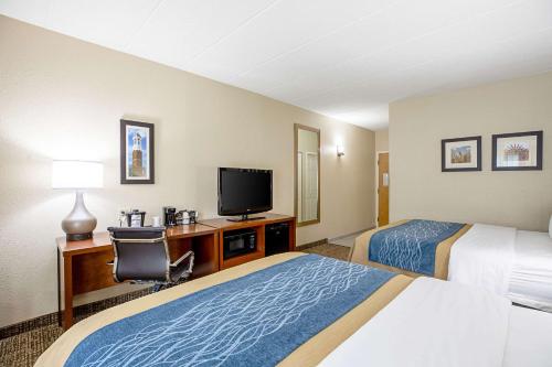 a hotel room with two beds and a flat screen tv at Comfort Inn Indianapolis North - Carmel in Carmel