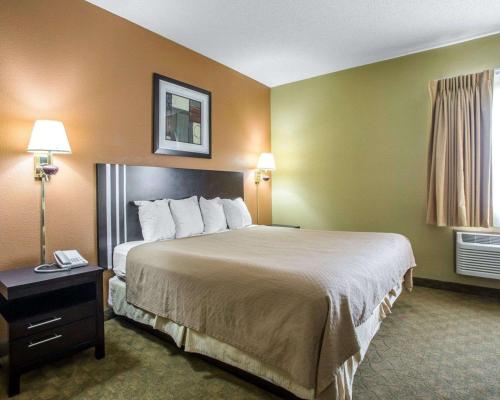 a hotel room with a large bed and a window at Quality Inn Merrillville in Merrillville