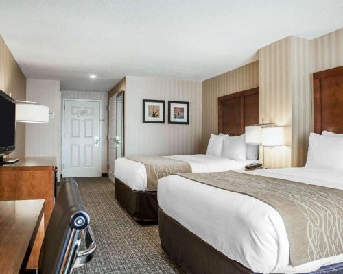 a hotel room with two beds and a flat screen tv at Comfort Inn & Suites Sturbridge-Brimfield in Sturbridge
