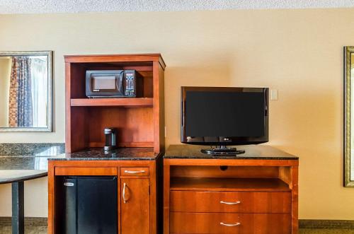 a television on a wooden entertainment center with a microwave at Quality Inn Chicopee-Springfield in Chicopee