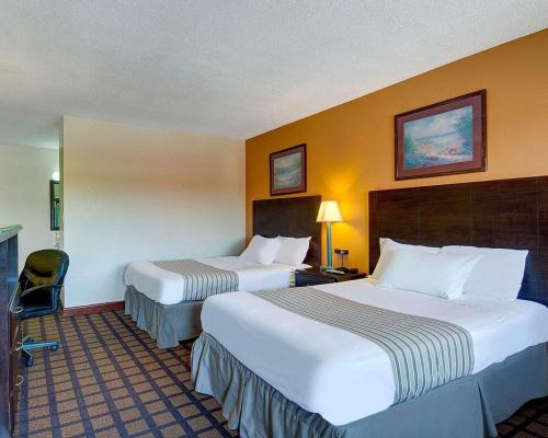 una habitación de hotel con 2 camas y una silla en Econo Lodge, en Sharon