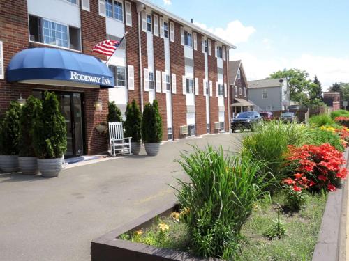 a building with an american flag in front of it at Rodeway Inn Logan International Airport in Revere