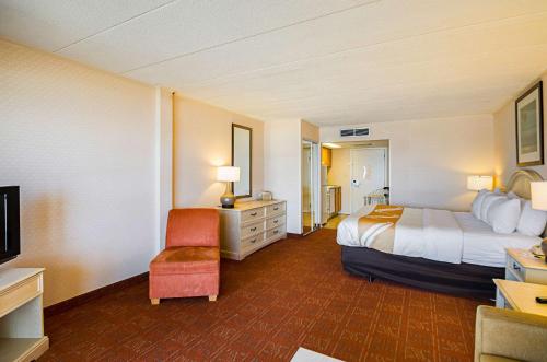 a hotel room with a bed and a chair at Quality Inn Oceanfront in Ocean City