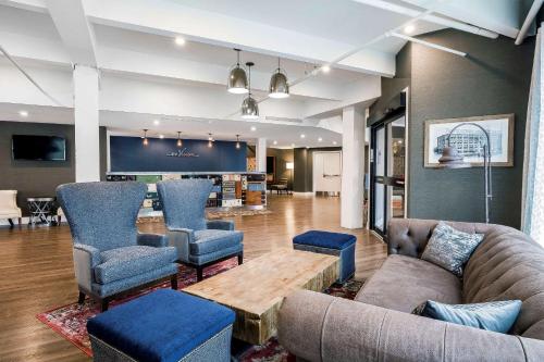 a living room with a couch and chairs and a table at enVision Hotel Boston-Everett in Boston