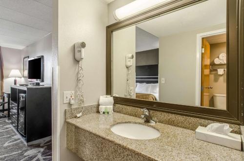 a bathroom with a sink and a large mirror at La Casa Inn & Suites-Middleboro in Middleboro