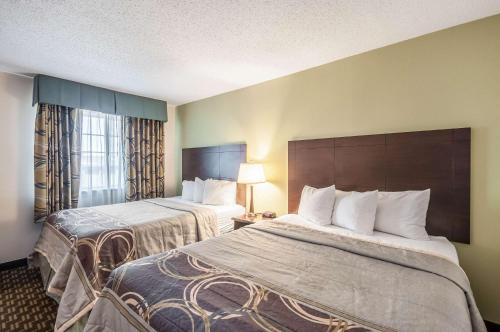 a hotel room with two beds and a window at MainStay Suites Frederick in Frederick