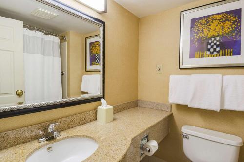 La salle de bains est pourvue d'un lavabo, de toilettes et d'un miroir. dans l'établissement Quality Inn Boston-Revere, à Revere