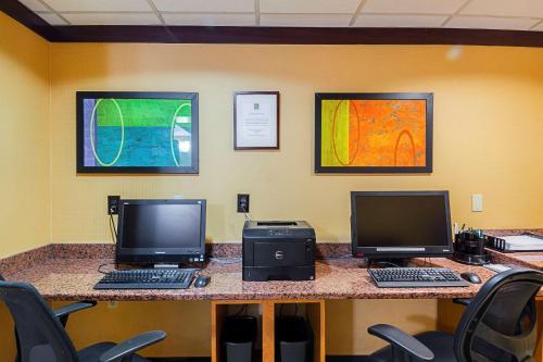 a desk with two monitors and two computers on it at Quality Inn Boston-Revere in Revere