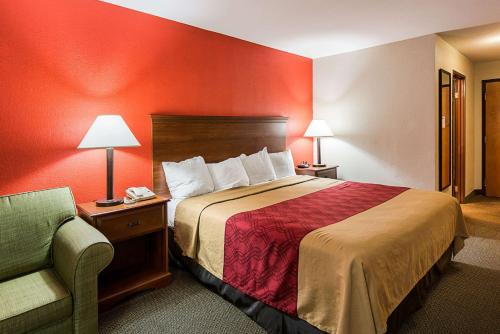 a hotel room with a bed and a chair at Econo Lodge Andrews AFB in Clinton