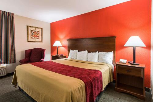 a hotel room with a bed and a red wall at Econo Lodge Andrews AFB in Clinton