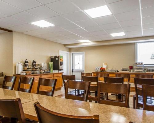 a dining room with tables and chairs and a kitchen at Quality Inn & Suites South Portland in South Portland