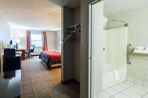 a hotel room with a bathroom with a bed and a shower at Quality Inn Solomons - Beacon Marina in Solomons