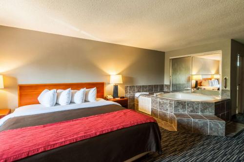 a hotel room with a bed and a bath tub at Quality Inn Solomons - Beacon Marina in Solomons