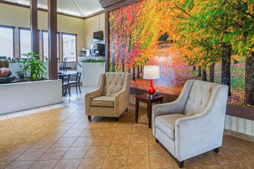 a lobby with two chairs and a painting on the wall at Quality Inn & Suites Frostburg-Cumberland in Frostburg