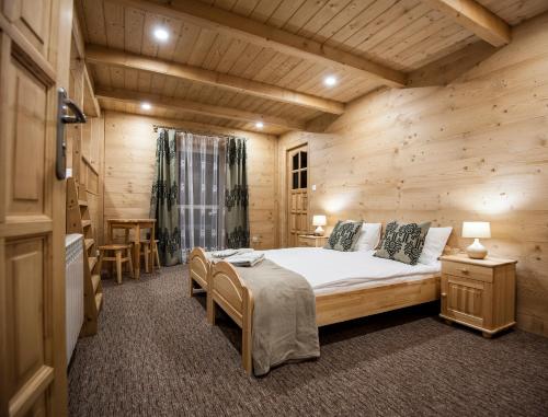 a bedroom with a bed in a wooden cabin at Osada Groń in Groń