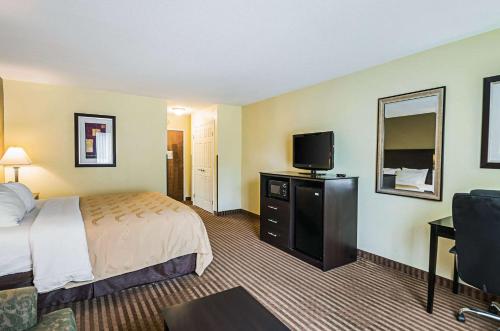 a hotel room with a bed and a flat screen tv at Quality Inn & Suites Frostburg-Cumberland in Frostburg