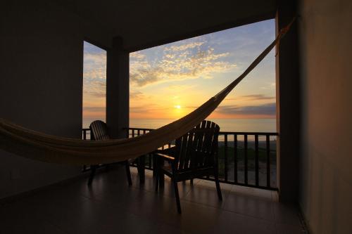 a hammock on a balcony with a view of the ocean at Punta Zicatela Hotel - Adults Only in Puerto Escondido