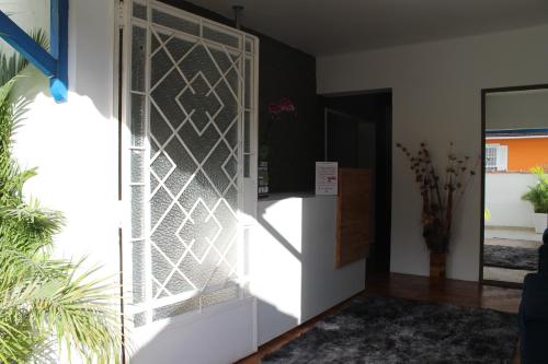 szklane drzwi w pokoju z rośliną w obiekcie Pousada Solar Teresa w mieście Petrópolis