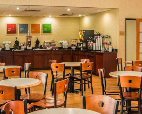 a restaurant with tables and chairs and a counter at Comfort Inn in Birch Run