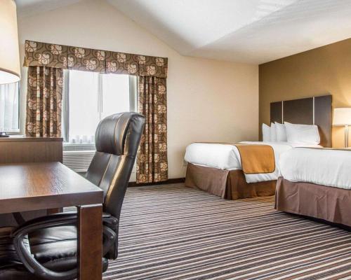 A bed or beds in a room at Quality Inn & Suites