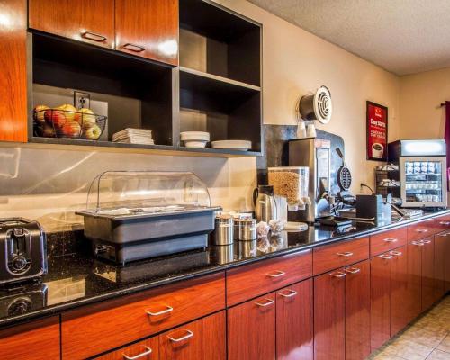 a kitchen with wooden cabinets and a counter top at Econo Lodge Freeport - Brunswick Area in Freeport