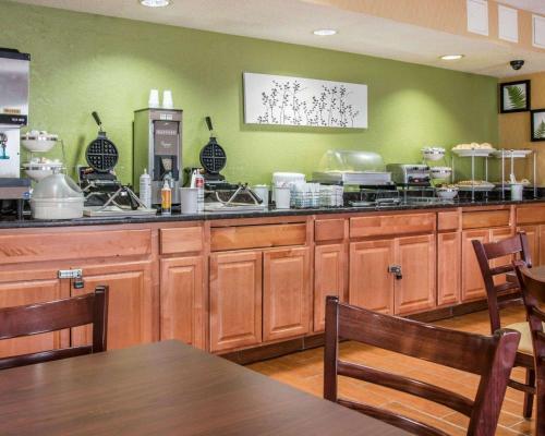 a large kitchen with wooden cabinets and a table and chairs at Sleep Inn & Suites Grand Rapids Southeast - Kentwood in Grand Rapids