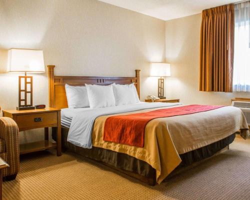 a hotel room with a large bed and two lamps at Quality Inn Ironwood in Ironwood