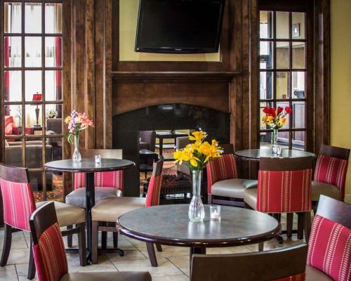 a restaurant with tables and chairs and a fireplace at Quality Inn & Suites Port Huron in Port Huron