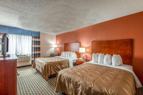 a hotel room with two beds and a television at Country Inn & Suites by Radisson, Muskegon, MI in Muskegon