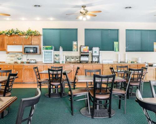 a restaurant with tables and chairs and a counter at Quality Inn & Suites Beachfront in Mackinaw City