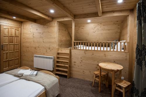 a room with a bed and a table in a cabin at Osada Groń in Groń