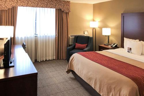 um quarto de hotel com uma cama e uma cadeira em Comfort Inn Farmington Hills em Farmington Hills