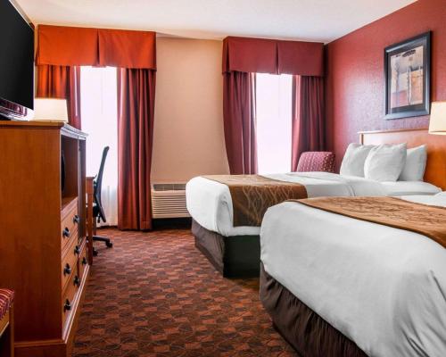 a hotel room with two beds and a television at Comfort Inn & Suites and Conference Center in Mount Pleasant