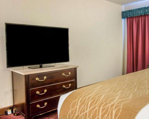 a bedroom with a television on a dresser with a bed at Comfort Inn Lakeside in Mackinaw City