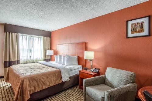 a hotel room with a bed and a chair at Country Inn & Suites by Radisson, Muskegon, MI in Muskegon