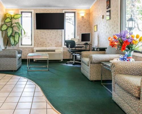 a lobby with couches and a living room with a tv at Rodeway Inn Madison Heights - Detroit in Madison Heights