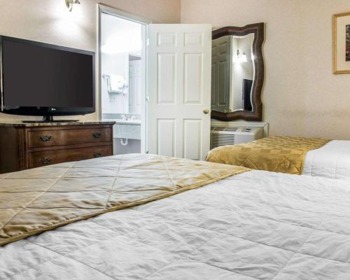 a bedroom with two beds and a flat screen tv at Clarion Hotel Beachfront in Mackinaw City