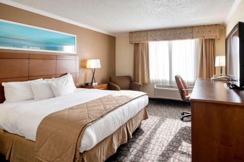 a hotel room with a bed and a desk at Clarion Hotel Detroit Metro Airport in Romulus