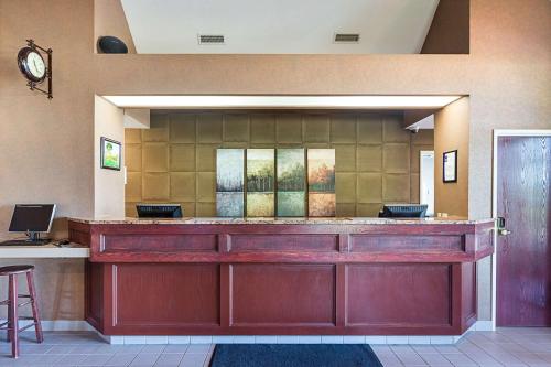 a lobby with a bar with a clock on the wall at Sleep Inn & Suites Bay View Acme - Traverse City in Traverse City