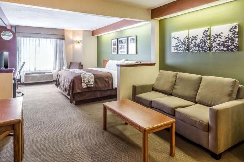Habitación de hotel con sofá y cama en Sleep Inn & Suites Acme - Traverse City, en Traverse City