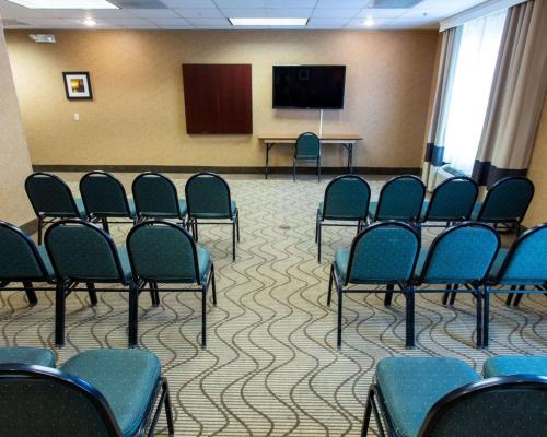 a conference room with chairs and a screen and a podium at Comfort Suites Grand Rapids South in Grand Rapids