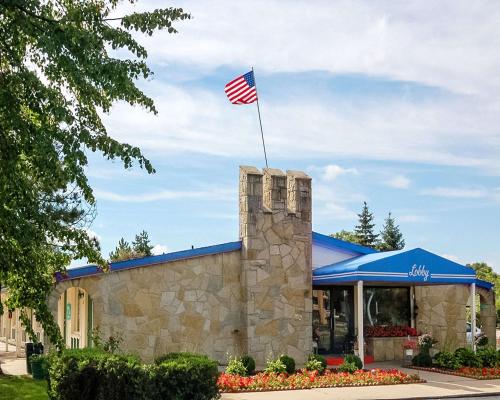 a building with an american flag on top of it at Rodeway Inn Madison Heights - Detroit in Madison Heights
