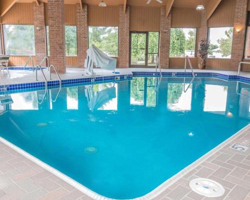 a large pool with blue water in a building at Quality Inn Grand Rapids North in Grand Rapids