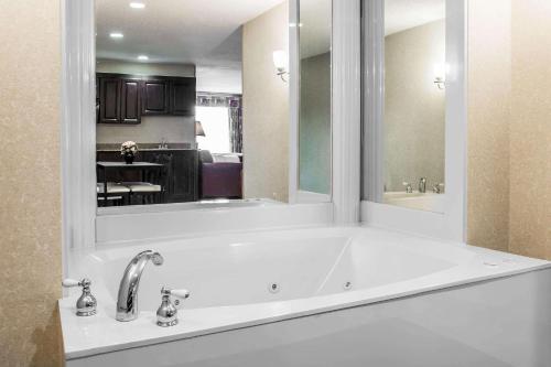 a large white bath tub with a large mirror at Comfort Suites Canton - Detroit in Canton