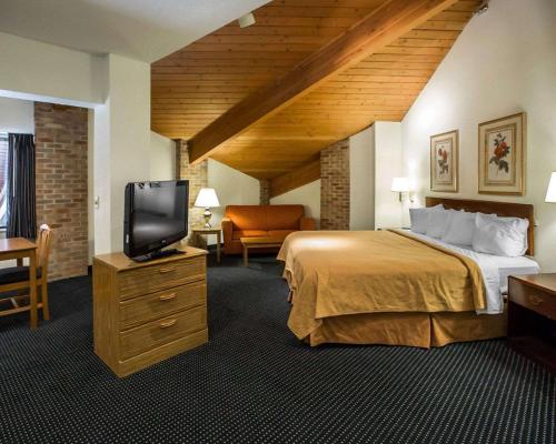 a hotel room with a bed and a flat screen tv at Quality Inn - Dundee in Dundee