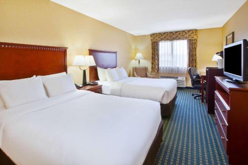 a hotel room with two beds and a flat screen tv at Quality Inn Marshall near I-69 in Marshall