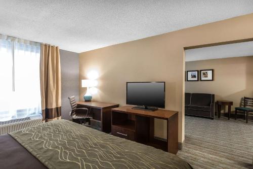 a hotel room with a bed and a flat screen tv at Comfort Inn Bay City - Riverfront in Bay City