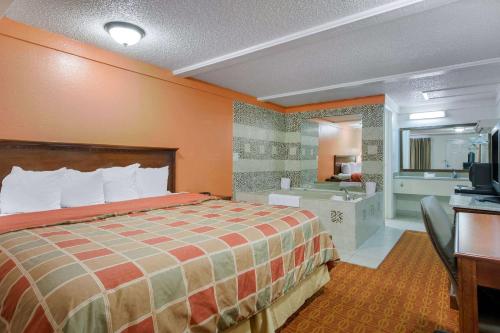 a hotel room with a bed and a bathroom at Rodeway Inn Auburn Hills in Auburn Hills